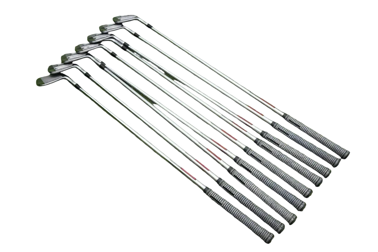 Set of golf clubs arranged on a textured surface